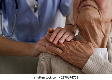 Unrecognizable female doctor expressing care towards an elderly lady, comforting her and holding hands. Two adult women of different age. Family values concept. lose up, copy space, background. - Shutterstock ID 2179674701