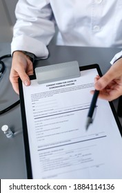 Unrecognizable Female Doctor Offering A Pen To Sign The Coronavirus Vaccine Consent Form