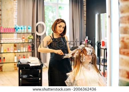 Similar – Foto Bild Abgeschnittene, nicht erkennbare Friseurin bei der Verwendung eines elektrischen Trimmers an den Haaren eines männlichen Kunden im Salon