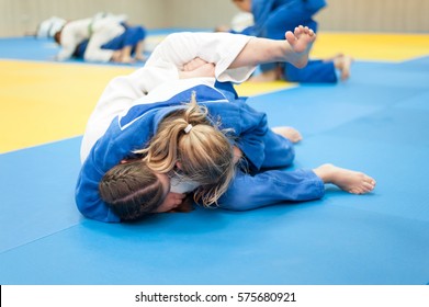 Unrecognizable Female Judoka In Blue Judo Gi Keeps The Opponent In The Hold Down