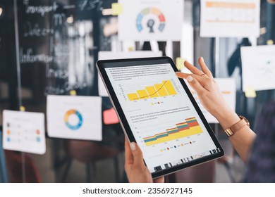 Unrecognizable female marketer checking financial report with infographics while browsing web document on modern touch pad, cropped entrepreneur with digital tablet reading business information - Shutterstock ID 2356927145