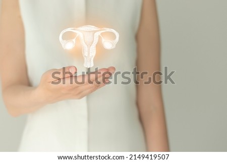 Unrecognizable female patient in white clothes, highlighted handrawn uterus in hands. Human reproductive system issues concept.
