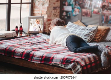 Unrecognizable Female Relaxing On Comfortable Bed With Checkered Blanket And Watching Retro TV At Home