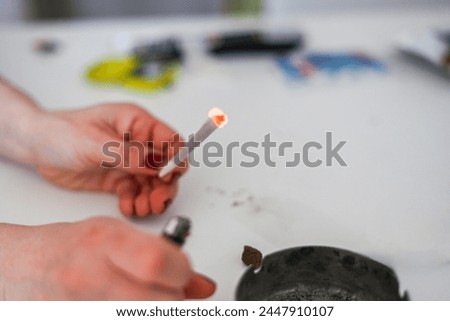 unrecognizable female young adult person prepare smoke hashish tobacco cigarette joint with filter at home on white table for personal health relax use
