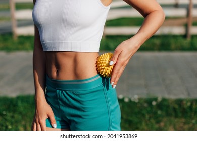 Unrecognizable Fit Body Of Young Woman Massaging Waist Spiky Rubber Yellow Ball For Muscle Relaxation And Recovery After Workout. 