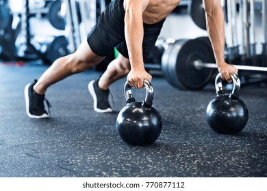 Unrecognizable fit man in gym doing push ups on kettlebells - Powered by Shutterstock