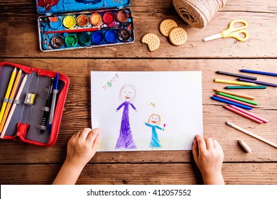 Unrecognizable girl drawing picture her   her mother