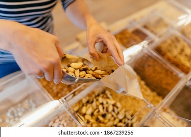 Unrecognizable Girl Put Nuts In Paper Bag Customer Buying Groceries In Zero Waste Shop Or Local Home Bakery. Buying Foods Without Plastic Packaging.