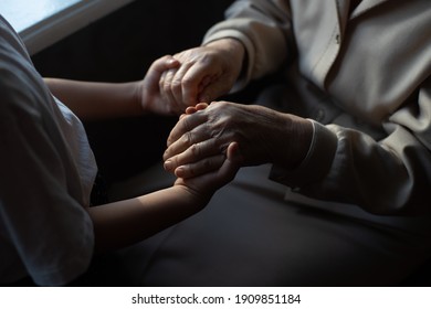 Unrecognizable Grandmother And Her Granddaughter Holding Hands.