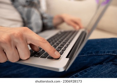 Unrecognizable guy using laptop working online typing keyboard.