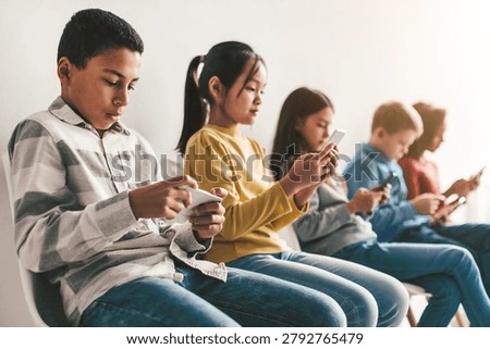 Unrecognizable Kids Using Smartphones While Sitting Side By Side, Technology Addiction Concept