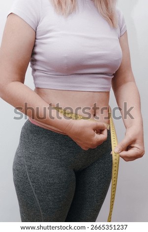 Unrecognizable lady checking result of weight loss diet or liposuction. Overweight woman measuring her fat belly. Beauty, shape, healthy and health care female concept.