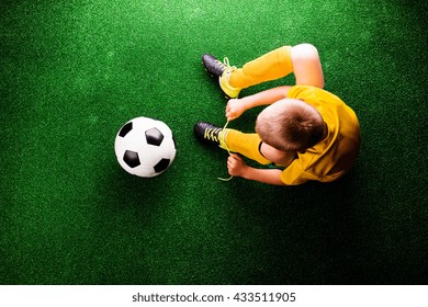 Unrecognizable little football player against green grass, studi - Powered by Shutterstock