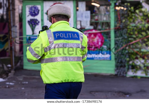 Unrecognizable local police agent. Romanian police\
man, traffic police man (Politia Rutiera) directing traffic in\
Bucharest, Romania,\
2020