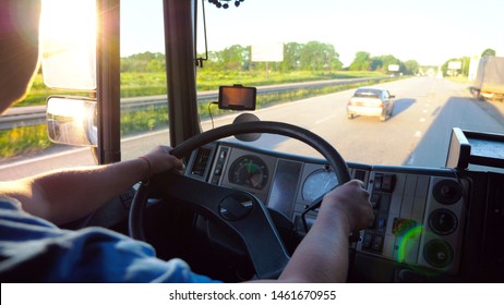 Unrecognizable Lorry Driver Holding Hands On Steering Wheel And Controlling His Truck Riding To Destination. Close Up Steering Wheel And Dashboard Of Truck. View On Traffic From Inside Cabin. Slow Mo