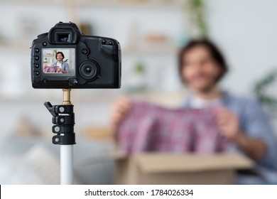 Unrecognizable male blogger shooting video for followers, unpacking mail box, selective focus on camera, home interior - Shutterstock ID 1784026334