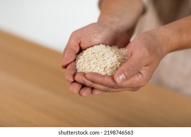 Unrecognizable Male Hands With Handful Of Rice, Closeup Shot. Cropped Of Man Holding Grain, Going To Cook Meal For Hungry Family, Copy Space. Crisis And Hunger, Poverty Concept