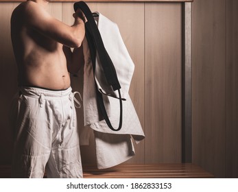 Unrecognizable Male Judoka Putting On White Judogi