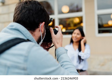 Unrecognizable Male Photographer Doing A Photo Session With A Latin Model On A City Street. Fashion Photo Shoot. People Working