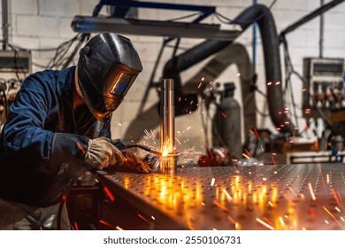 Unrecognizable male welder with protective facial mask and gloves welding a piece of metal in a factory - Powered by Shutterstock