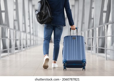 Unrecognizable Man With Bag And Suitcase Walking In Airport Terminal, Rear View Of Young Male On His Way To Flight Boarding Gate, Ready For Business Travel Or Vacation Journey, Cropped, Copy Space