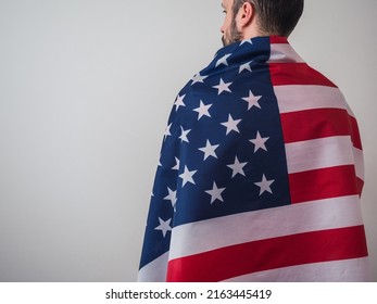 Unrecognizable Man From Behind, Hugging The Flag Of The United States And With Copy Space. Ready For The 4th Of July Celebration