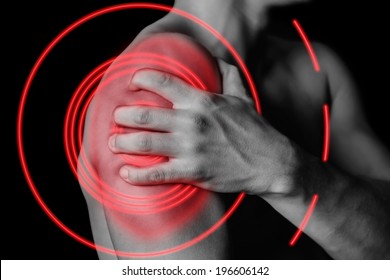Unrecognizable man compresses his shoulder, pain in the shoulder, side view, pain area of red color