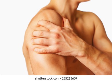 Unrecognizable man compresses his shoulder, pain in the shoulder, side view. Shoulder close-up
