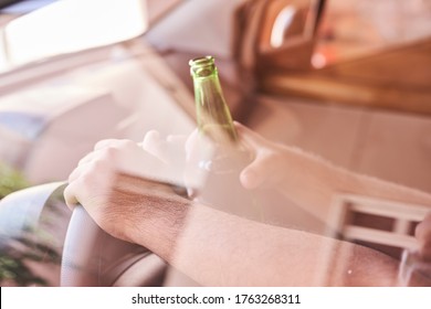 An unrecognizable man drinking beer while driving car. Concepts of driving under the influence, drunk driving or impaired driving
