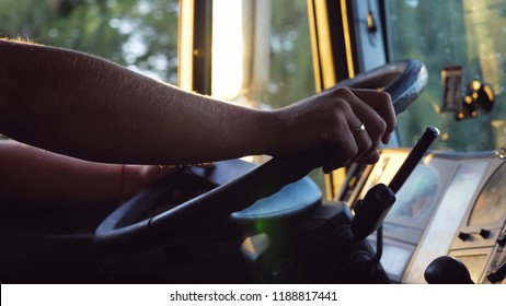 Unrecognizable Man Holding His Hands On Steering Wheel And Driving Car At Country Road On Warm Summer Day. Truck Driver Rides To Destination. View From The Lorry Cab. Slow Motion Close Up