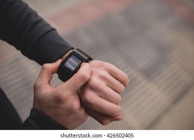 Unrecognizable man pushing button on sport wristwatch with text ready.from above