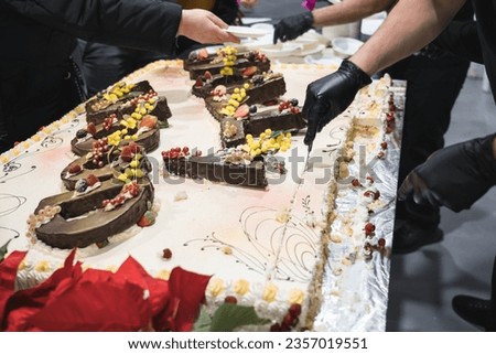 unrecognizable man serving big cake to guests celebrating the opening of a new store