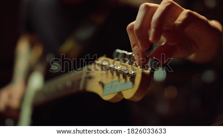 Similar – Image, Stock Photo Hand holding an acoustic guitar with black background with a dramatic and cinematic tone in chiaroscuro