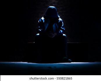 unrecognizable man waiting on the dark room with single light source making outer shape - Shutterstock ID 550821865