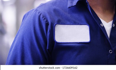 unrecognizable man wearing blue uniform shirt with empty name white tag or patch, worker or employee Identification. - Shutterstock ID 1726609162