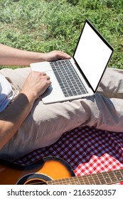 Unrecognizable Man In White Pants Outside Having Picnic And Using Laptop, Working Outdoors