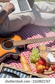 Unrecognizable Man In White Pants Outside Having Picnic And Using Laptop, Working Outdoors. Summer Leisure And Fun