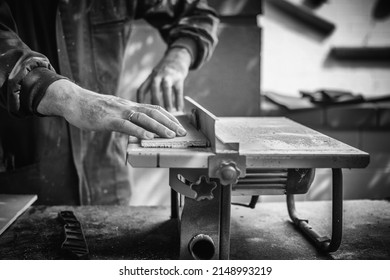 Unrecognizable Man working And Cutting The Wood On A Machine Tool Called A Table Saw In A Carpentry Workshop. Person Doing DIY In The Garden Of His House. DIY And Craft Concept. Detail