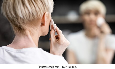 Unrecognizable Mature Woman Using Cotton Pads Doing Facial Skincare Routine In Bathroom Indoor. Back View, Panorama, Selective Focus