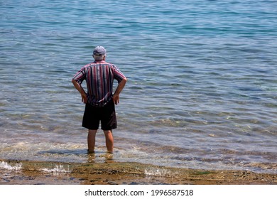 
Unrecognizable Old Man  Standing On The Beach And Looking At The Sea. Sunny Summer Day