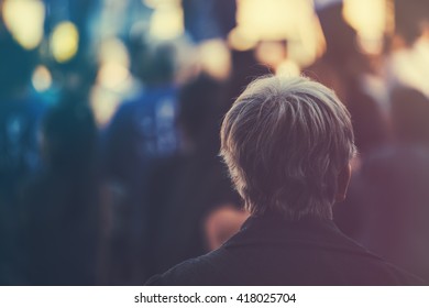 Unrecognizable Older Adult Person On Outdoor Political Meeting From Behind, Looking Toward Gathered Crowd And Stage.