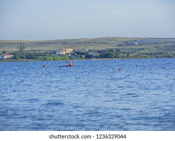 Unrecognizable Older Man Rowing Kayak In The Sea At Beautiful Sunny Evening.