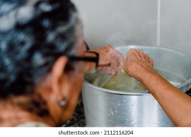 Unrecognizable Older Woman Making Lunch In The Kitchen And Stirring Soup.