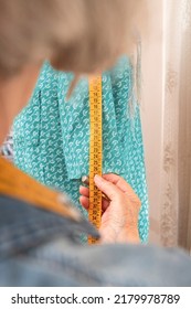 Unrecognizable Older Woman Sizing A Turquoise Garment