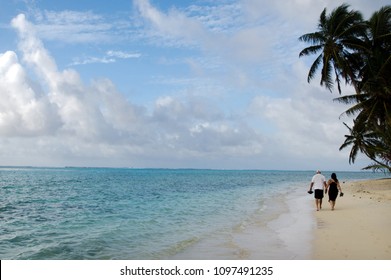 Unrecognizable Pacific Island Couple Walks On The Beach At  Muri Lagoon In Rarotonga Cook Islands During Sunrise.