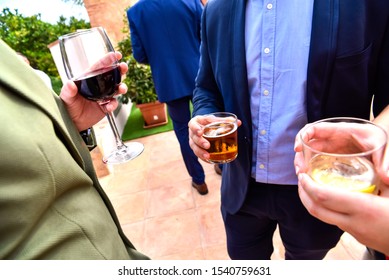 Unrecognizable People With Drinks In Their Hands Talk To Each Other About Business At A Networking Event