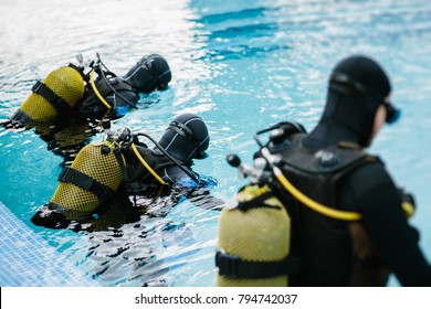 Unrecognizable people in equipment diving in training pool. - Powered by Shutterstock