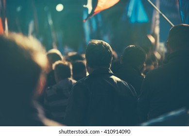 Unrecognizable people on the street during political meeting, audience from behind, selective focus and retro toned image with lens flare. - Shutterstock ID 410914090