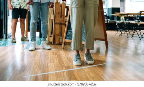 Unrecognizable People Queuing Up Keeping Social Distance To Enter A Restaurant