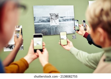 Unrecognizable People Scanning QR Code Using Smartphones To Get More Information About Photo On Wall At Exhibition